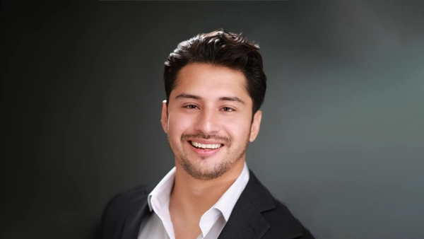 Emmanuel Monroy wearing a dark suit jacket and white collared shirt